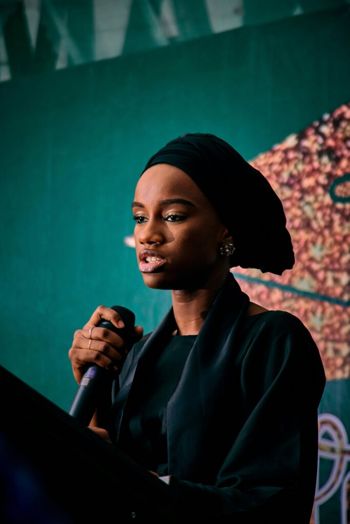 Professional woman speaking confidently to a group using a microphone during a presentation